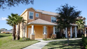 A residential house with a front porch, palm trees, and a clear sky. - 1507 Dream (Clermont)