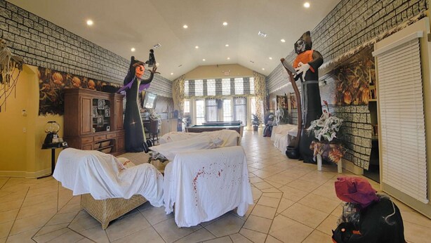 A spacious room with a high ceiling, a billiards table, and a large window providing natural light. - 4562 Seven Dwarfs (Kissimmee)