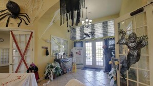 A room with a large spider decoration on the ceiling, a 'Massage' sign, and a 'Caution' sign near the entrance. - 4562 Seven Dwarfs (Kissimmee)