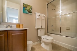 A bathroom with a toilet, sink, and shower.