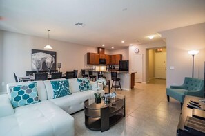Relax in this stylish living room with a sofa, kitchen area, and dining space.