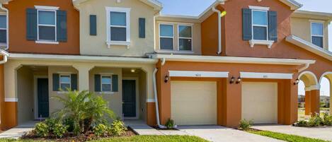 A two-story residential building with a garage, numbered 5133, and a well-maintained lawn.