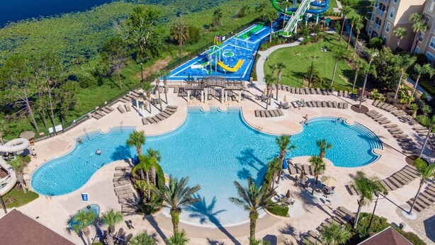 Ein Resort mit mehreren Schwimmbecken, einem Wasserpark und einer gepflegten Rasenfläche.