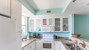 A kitchen with white cabinets, a microwave, a stove, a sink, and granite countertops. - 425 Little Harbor (Ruskin)
