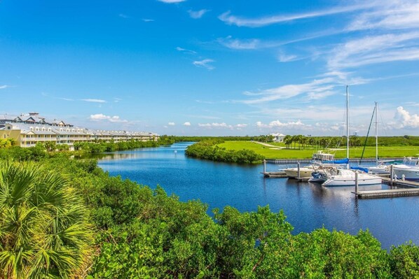 A riverside hotel with a marina, lush greenery, and a clear blue sky. - 425 Little Harbor (Ruskin)