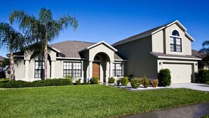 A two-story house with a front entrance, a garage, and a well-maintained lawn. - 217 Legacy Park (Davenport)