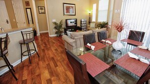 A dining area with a glass table, red placemats, and dark wooden chairs. - 721 Terrace Ridge (Davenport)
