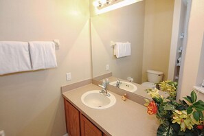A bathroom with two sinks, a mirror, and a toilet. There are towels hanging on the wall. - 3175 Encantada (Kissimmee)