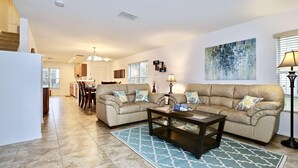 A living room with a beige sectional sofa, a coffee table, and a patterned rug. - 5113 Compass Bay (Kissimmee)