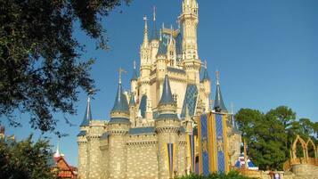 A castle-like structure with multiple towers and spires, surrounded by greenery.
