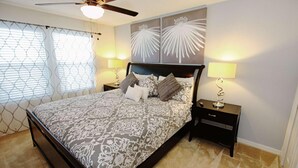 A bedroom with a bed, two bedside tables, a ceiling fan, and a window with blinds. - 3207 Compass Bay (Kissimmee)