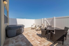 A patio with a hot tub, wicker chairs, and a table. - 5137 Compass Bay (Kissimmee)