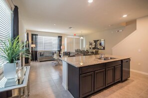 A spacious kitchen with a large island, dark cabinetry, and a modern design.
