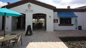 A building labeled "Tu Casa Bar & Lounge" with outdoor seating and a covered patio area.