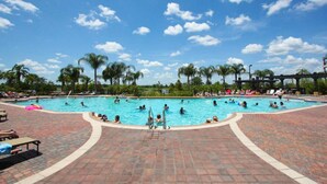 A large outdoor swimming pool surrounded by palm trees and a covered pavilion. - Vista Cay 4804 (Orlando)