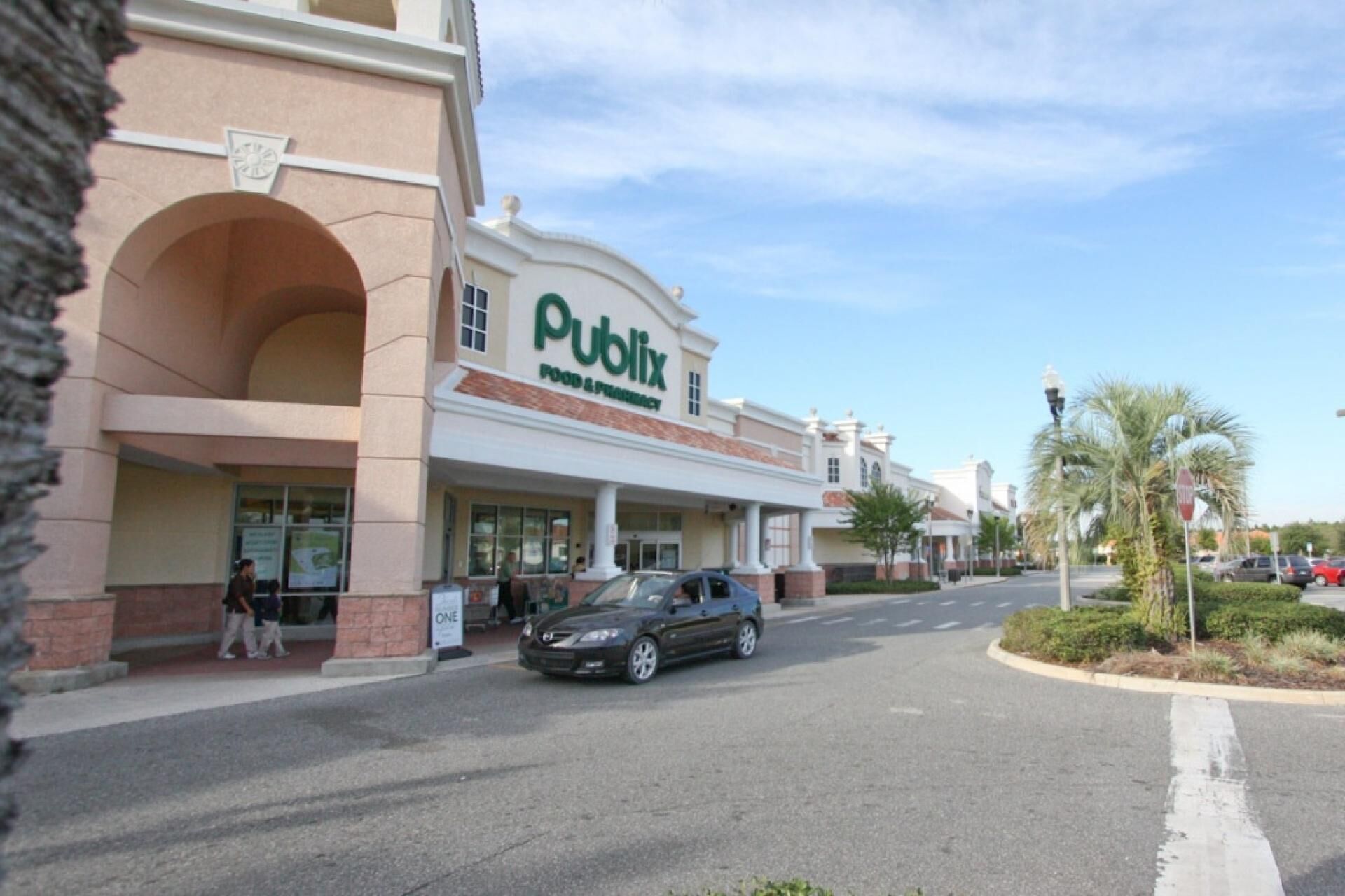 A Publix store with a clear storefront and a parking lot in front.