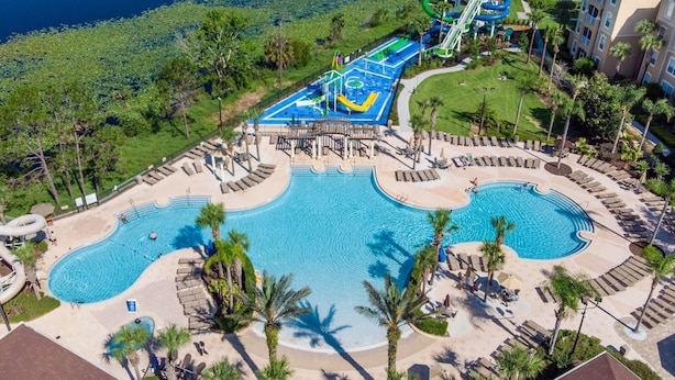 Resort com várias piscinas, parque aquático e área de gramado bem cuidada.