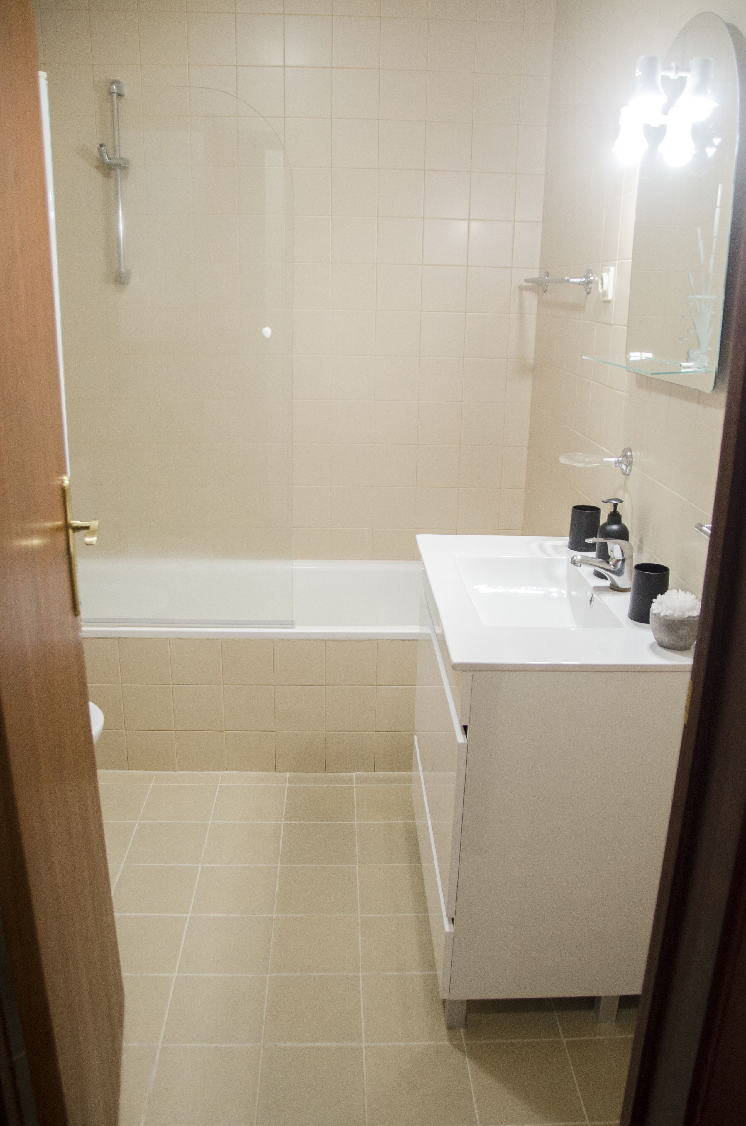 Un bagno con una vasca, un lavandino e uno specchio.