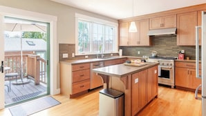Una cocina moderna con armarios de madera, una isla grande y vistas al exterior.