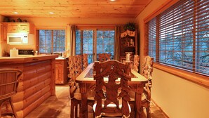 A log cabin interior with a dining area, wooden furniture, and a kitchen with a microwave. - Walk 2 Ski/Hiking/Biking Trails w/Spa/Pool Table/Sauna/Fenced Yard, Pet Friendly (Big Bear Lake)