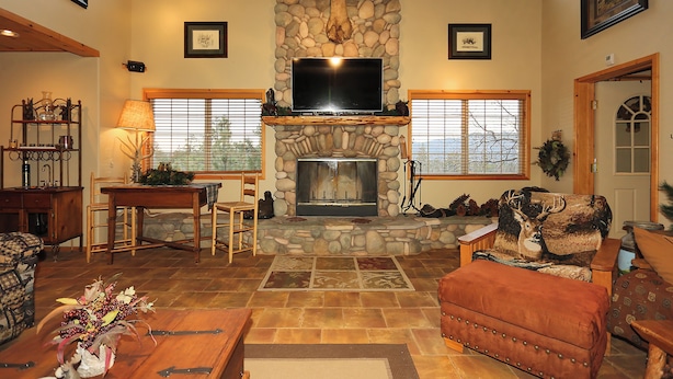 A cozy living room with a stone fireplace, a television, and comfortable seating. - Walk 2 Ski/Hiking/Biking Trails w/Spa/Pool Table/Sauna/Fenced Yard, Pet Friendly (Big Bear Lake)