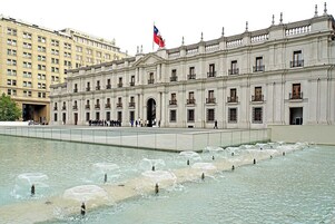 A large building with a fountain in front.