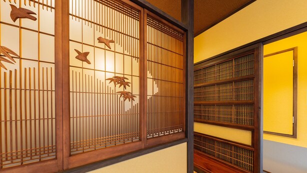 A traditional Japanese room with tatami flooring, sliding doors with wooden lattice, and a low ceiling. - Yadoya Asakusa Sen no Kaze (Tokyo)