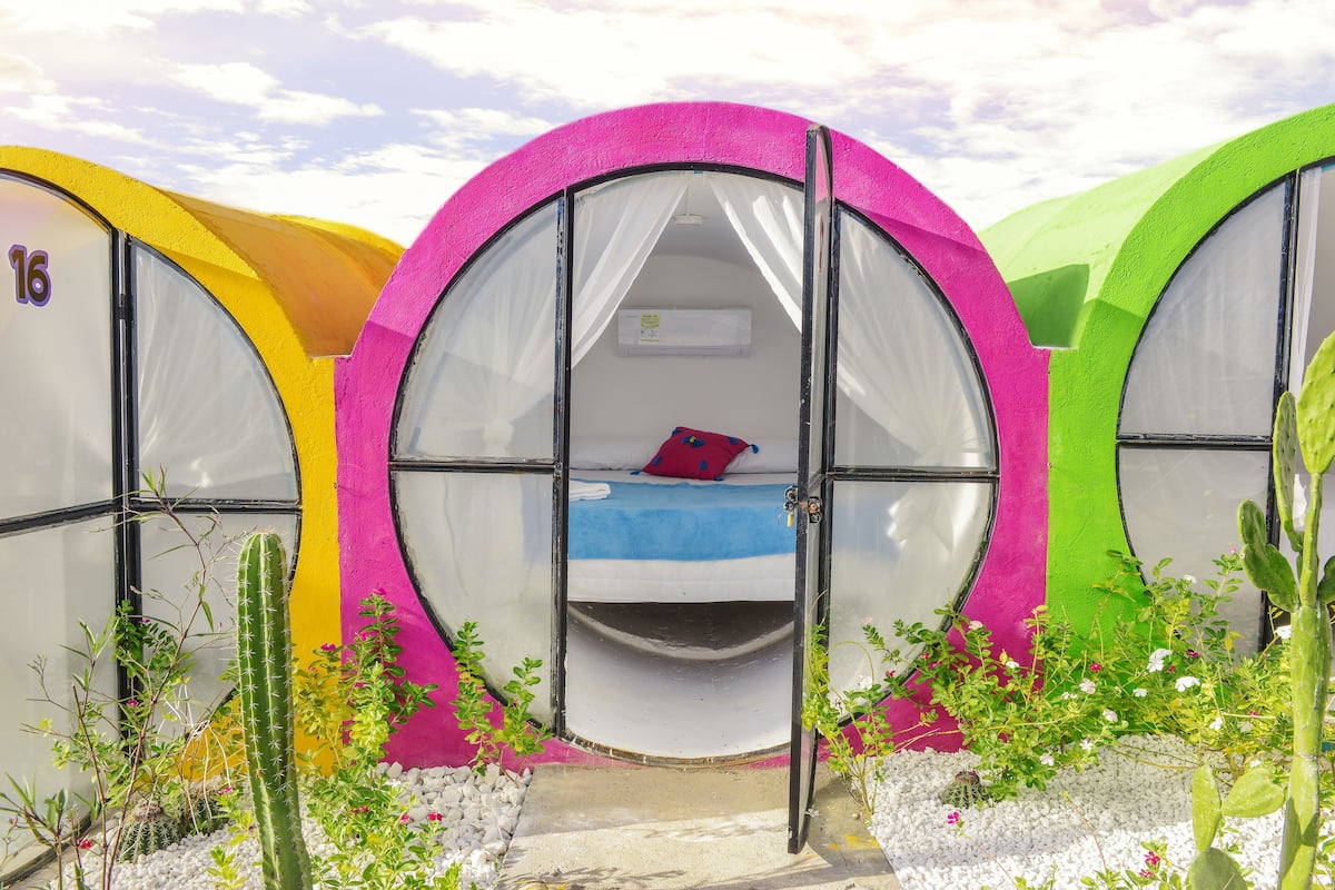Three colorful, circular tents with beds, each featuring a unique color.