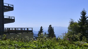 Un bâtiment doté d’un balcon donnant sur un paysage montagneux.