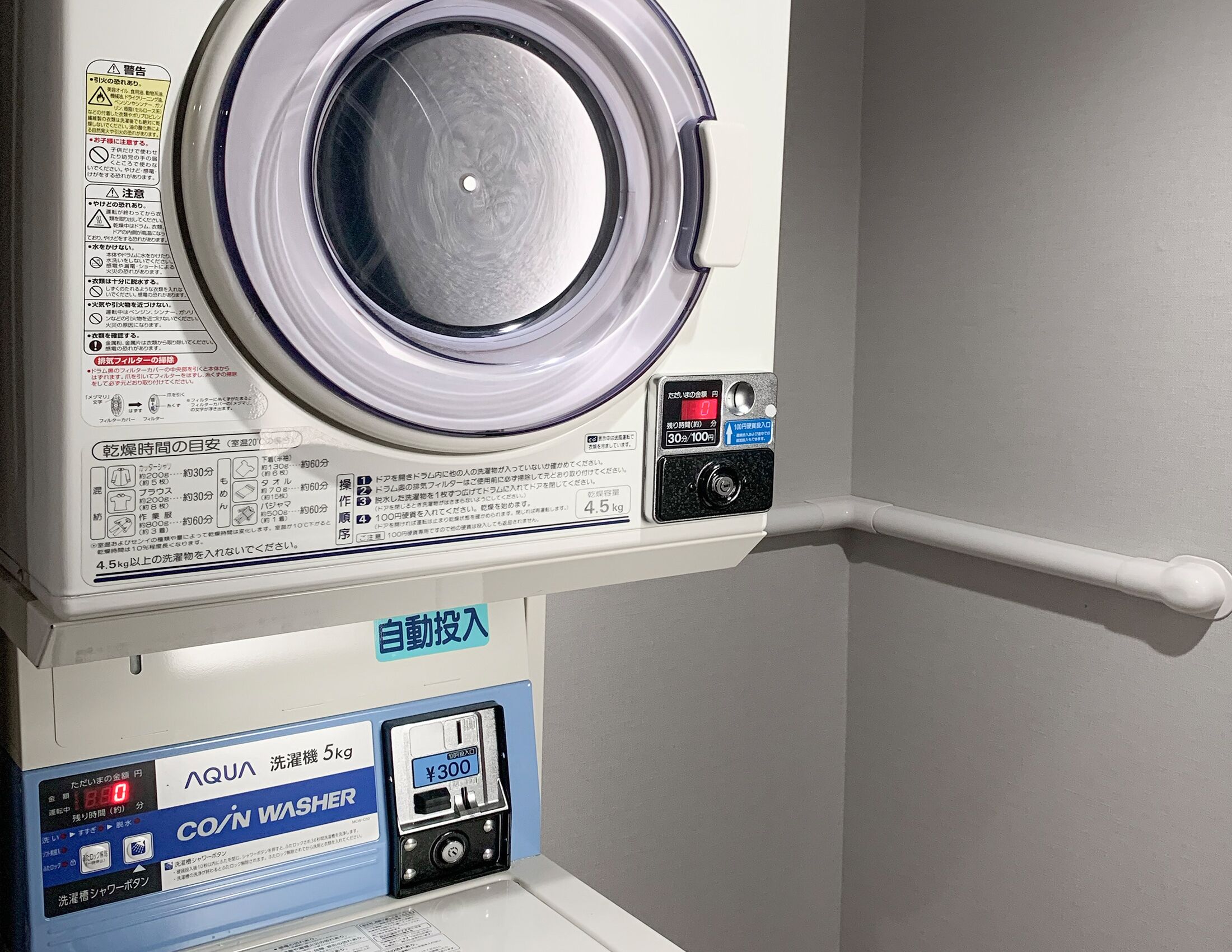 Vue de face d’un lave-linge doté d’un écran numérique et d’une interface à pièces.