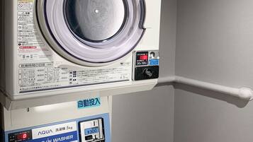 Vue de face d’un lave-linge doté d’un écran numérique et d’une interface à pièces.