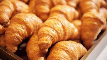 A display of golden-brown croissants arranged closely together.