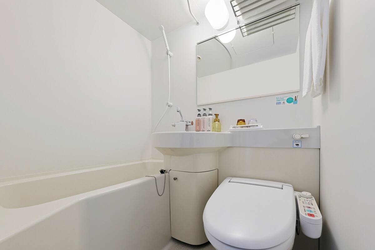 A modern bathroom with a bathtub, toilet, and sink.