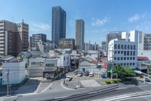 A cityscape with modern buildings, a parking lot, and a clear sky.