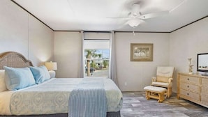 A bedroom with a bed, a chair, a dresser, and a ceiling fan. - On the Canal, by Beach, Kayaks, Dock, Fishing (St. Augustine)
