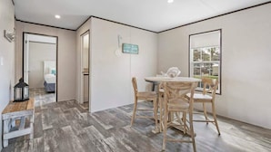 A room with a dining table and chairs, a window, and a door leading to another room. - On the Canal, by Beach, Kayaks, Dock, Fishing (St. Augustine)