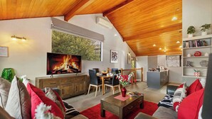 A modern living room with a fireplace, dining area, and kitchen. - SPACIOUS ALPINE LAKE VIEW SPA TOWNHOUSE WALK TO TOWN (Fernhill)