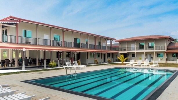 A hotel with a swimming pool, outdoor seating, and a covered area with tables and chairs. - Nilakma Lagoon (Negombo)