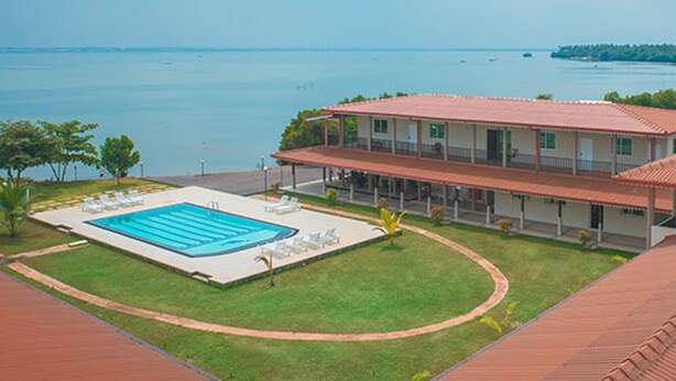 A hotel with a swimming pool, a covered outdoor area, and a view of the sea. - Nilakma Lagoon (Negombo)