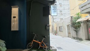 A narrow alley with a building on the left labeled "LEO 111 HOUSE HOSTEL CULTURE GALLERY" and a bicycle parked against the wall. - Leo 111 - Yancheng Pier 2 (Kaohsiung)