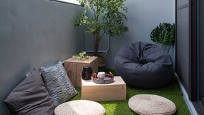 A cozy corner with a small seating area, a coffee table, and a plant. - Leo 111 - Yancheng Pier 2 (Kaohsiung)