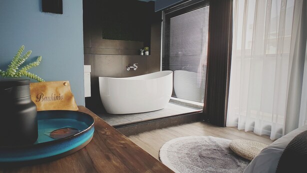 A modern bathroom with a freestanding bathtub, a sink, and a window with blinds. - Leo 111 - Yancheng Pier 2 (Kaohsiung)