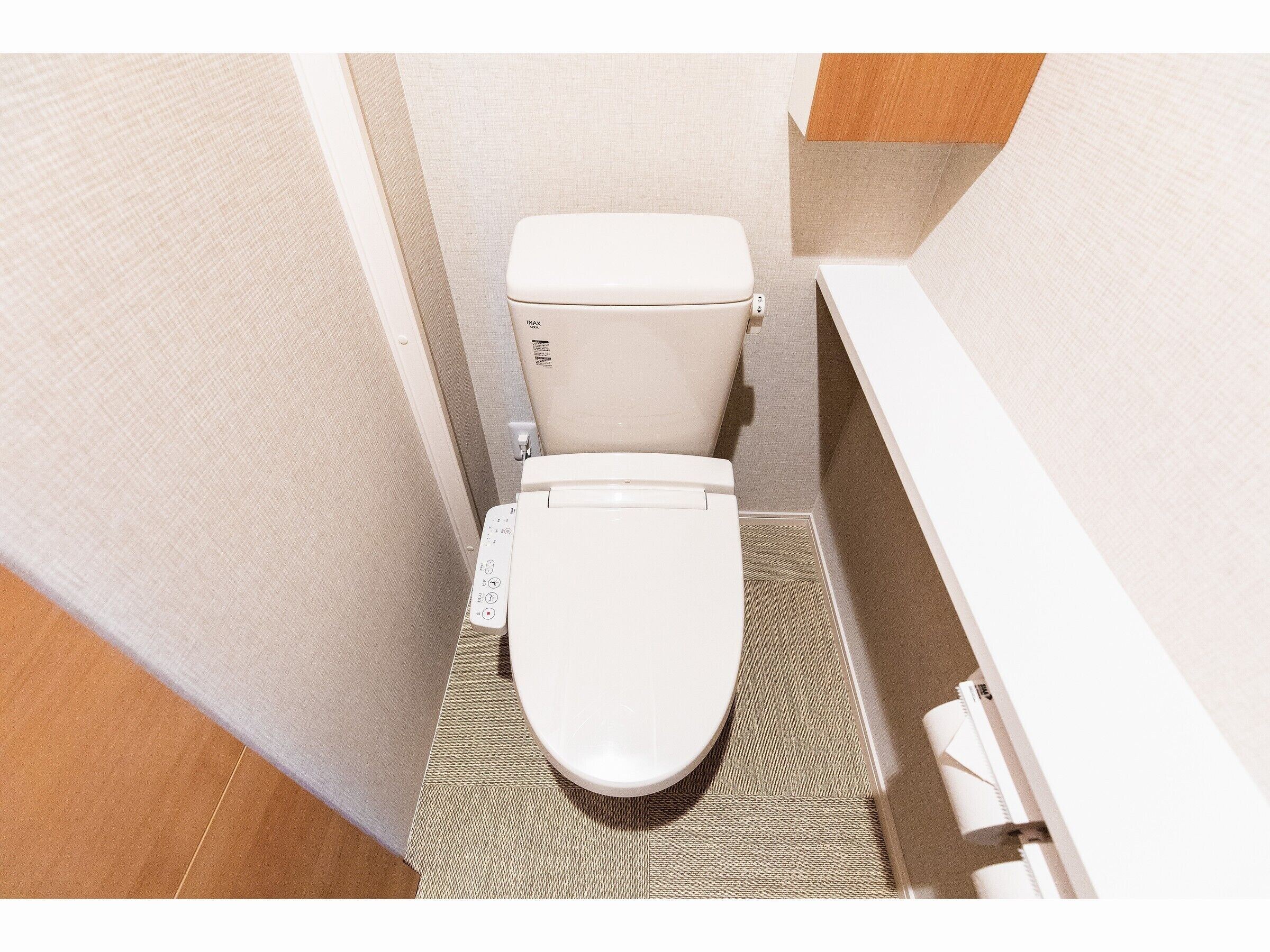 Un baño pequeño con inodoro, panel de control y zona de ducha.