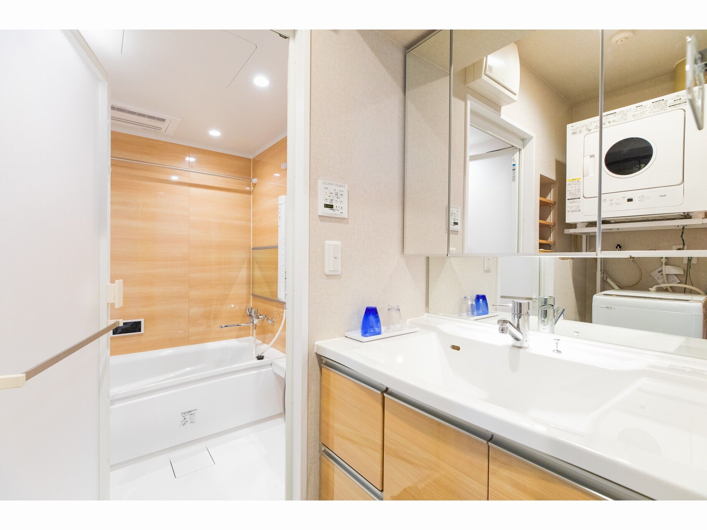 Un baño moderno con bañera, dos lavamanos y un espejo grande.