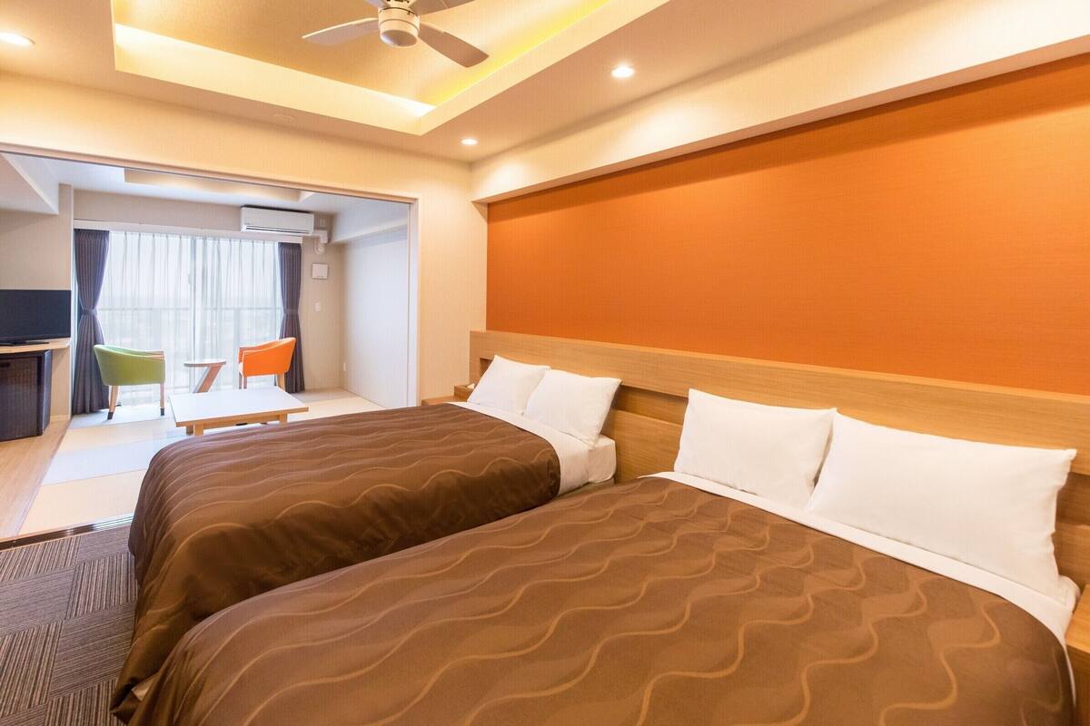 Una habitación de hotel con dos camas, un escritorio y una silla.