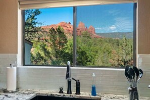 A bathroom with a window view of red rock formations and greenery. - Breathtaking Views Allows Pets! Hilltop Harmony - (Sedona)