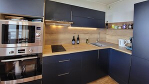 Eine moderne Küche mit eingebauter Mikrowelle, Backofen und Edelstahlgeräten.