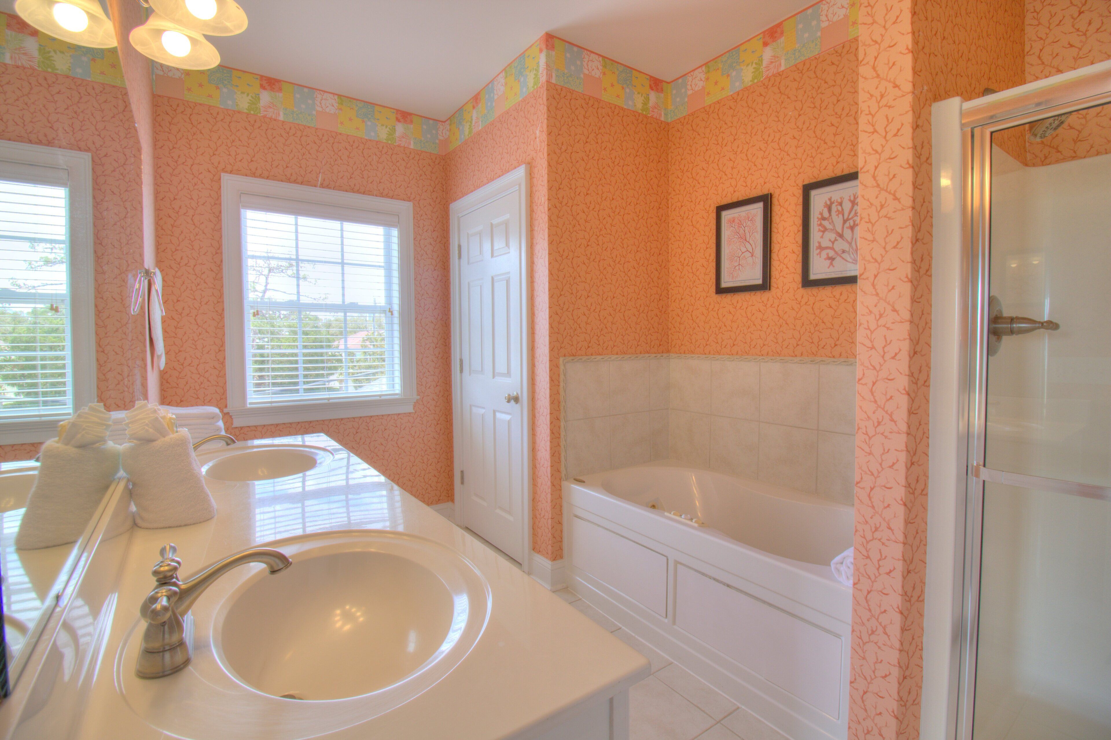 A bathroom with two sinks, a bathtub, and a shower.