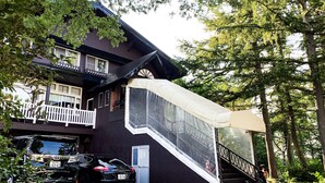 Une maison à deux étages dotée d’un balcon, d’un espace extérieur couvert et d’un escalier menant à l’étage supérieur.