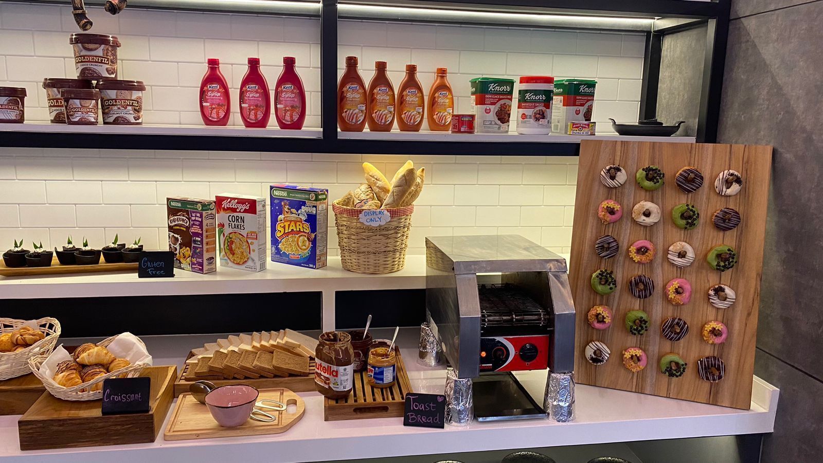 A bakery display with various baked goods, including croissants, bread, and a selection of donuts.
